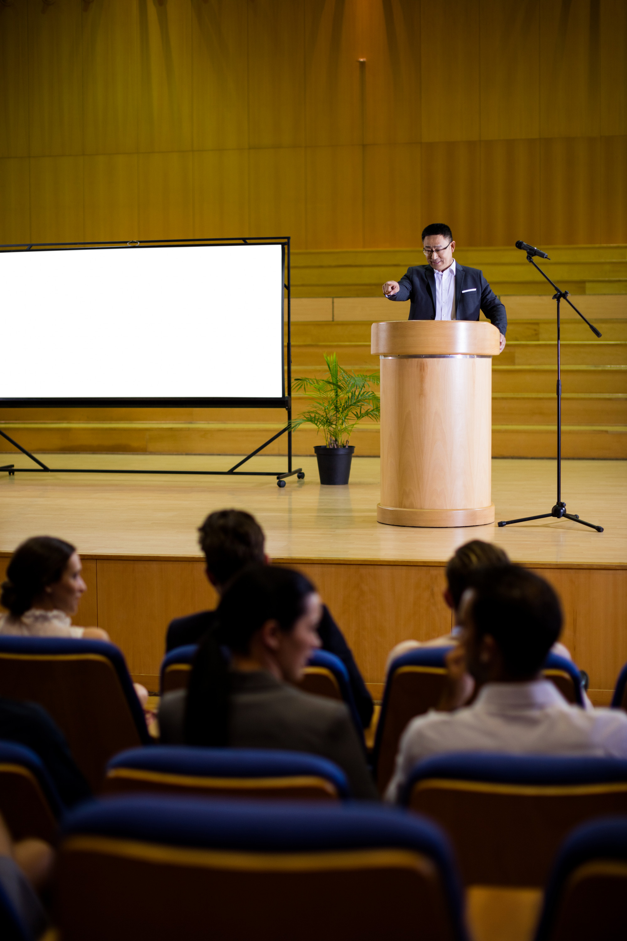 Person speaking at a podium in a conference hall